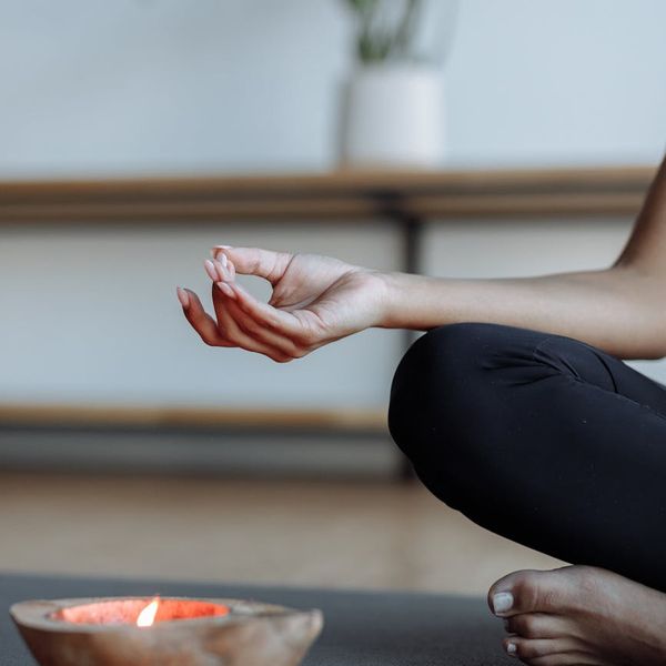 Close-up of a woman's hands in a meditative mudra gesture.